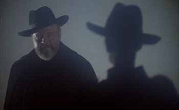 Movie still from “F for Fake” (1973), directed by François Reichenbach – A man with a hat and a beard is looking at another man with a hat and a beard; Close Up shot, Low angle