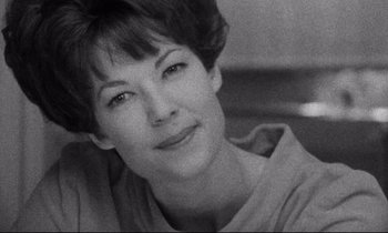 Movie still from “Faces” (1968), directed by John Cassavetes – Black and white photograph of a woman smiling for the camera; Close Up shot, Low angle