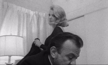 Movie still from “Faces” (1968), directed by John Cassavetes – An old black and white photo of a man and a woman; Medium shot, Low angle