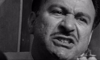 Movie still from “Faces” (1968), directed by John Cassavetes – A man with a frowning look on his face; Extreme Close Up shot, Low angle