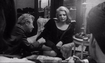 Movie still from “Faces” (1968), directed by John Cassavetes – A man and a woman sitting on a couch; Medium shot, Over the shoulder angle
