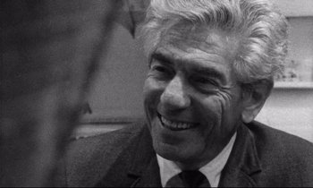 Movie still from “Faces” (1968), directed by John Cassavetes – An older man in a suit smiling for the camera; Close Up shot, Over the shoulder angle