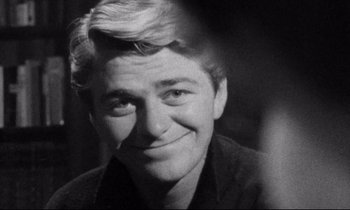 Movie still from “Faces” (1968), directed by John Cassavetes – Black and white photograph of a man smiling for the camera; Close Up shot, Over the shoulder angle