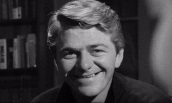 Movie still from “Faces” (1968), directed by John Cassavetes – A black and white photo of a man smiling; Close Up shot, High angle
