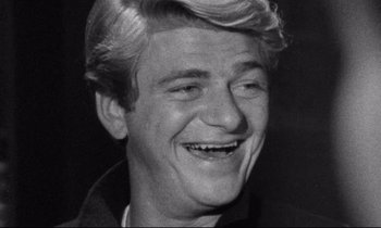 Movie still from “Faces” (1968), directed by John Cassavetes – Black and white photograph of a man smiling for the camera; Close Up shot, Low angle