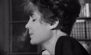 Movie still from “Faces” (1968), directed by John Cassavetes – A black - and - white photo of a woman smoking a cigarette; Close Up shot, Over the shoulder angle
