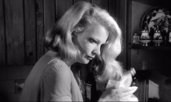 Movie still from “Faces” (1968), directed by John Cassavetes – A black and white photo of a woman brushing her blonde hair; Close Up shot, Low angle