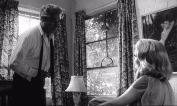 Movie still from “Faces” (1968), directed by John Cassavetes – A black and white photo of a man and a woman in front of a window; Medium shot, Over the shoulder angle