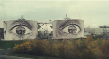 Movie still from “Faces Places” (2017), directed by Agnès Varda – A billboard with a picture of an eye on top of it; Extreme Wide shot, Low angle