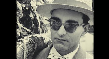 Movie still from “Faces Places” (2017), directed by Agnès Varda – A black and white photo of a man wearing a hat and sunglasses; Close Up shot, Low angle