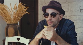 Movie still from “Faces Places” (2017), directed by Agnès Varda – A man wearing a hat and sunglasses eating a banana; Close Up shot, Low angle