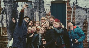 Movie still from “Faces Places” (2017), directed by Agnès Varda – A man taking a picture of a group of people; Wide shot, Overhead angle
