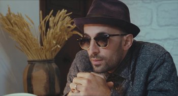 Movie still from “Faces Places” (2017), directed by Agnès Varda – A person wearing sunglasses and a hat; Close Up shot, Low angle