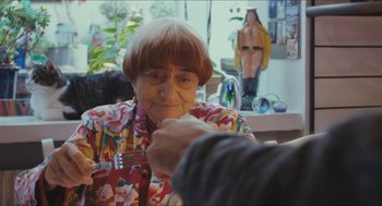 Movie still from “Faces Places” (2017), directed by Agnès Varda – An older woman sitting in front of a man; Close Up shot, Over the shoulder angle