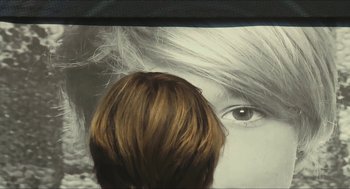 Movie still from “Faces Places” (2017), directed by Agnès Varda – A woman's face and a boy's hair; Extreme Close Up shot, Over the shoulder angle