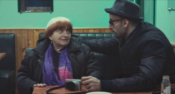 Movie still from “Faces Places” (2017), directed by Agnès Varda – An older woman sitting next to a younger man; Close Up shot, Over the shoulder angle
