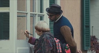 Movie still from “Faces Places” (2017), directed by Agnès Varda – An older man and a woman painting a window; Medium shot, Over the shoulder angle