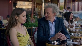 Movie still from “Emily in Paris” (2020), created by Darren Star – A man and a woman sitting at an outdoor table; Medium shot, Over the shoulder angle