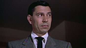 Movie still from “Fahrenheit 9/11” (2004), directed by Michael Moore – A person wearing a suit and tie; Close Up shot, Low angle