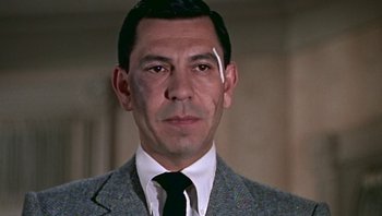 Movie still from “Fahrenheit 9/11” (2004), directed by Michael Moore – A person wearing a suit and tie; Close Up shot, Over the shoulder angle