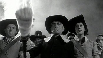 Movie still from “Fahrenheit 9/11” (2004), directed by Michael Moore – An old photo of a group of people in hats; Medium shot, Low angle