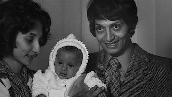 Movie still from “Fahrenheit 9/11” (2004), directed by Michael Moore – An old photo of a man holding a baby; Close Up shot, High angle