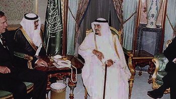 Movie still from “Fahrenheit 9/11” (2004), directed by Michael Moore – An old picture of a man sitting in a chair holding a cane; Medium shot, Over the shoulder angle