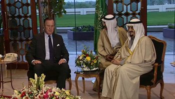 Movie still from “Fahrenheit 9/11” (2004), directed by Michael Moore – Two men and a woman sitting in a room; Medium shot, Over the shoulder angle