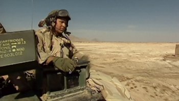 Movie still from “Fahrenheit 9/11” (2004), directed by Michael Moore – A man sitting on top of an atv in the desert; Medium shot, Low angle