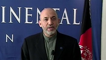 Movie still from “Fahrenheit 9/11” (2004), directed by Michael Moore – A man in a black suit is talking to the camera; Close Up shot, Low angle