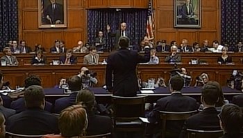 Movie still from “Fahrenheit 9/11” (2004), directed by Michael Moore – A man is speaking to a group of people in front of a crowd; Extreme Wide shot, Low angle