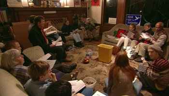 Movie still from “Fahrenheit 9/11” (2004), directed by Michael Moore – A group of people sitting in a living room; Wide shot, High angle