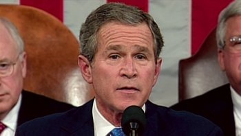 Movie still from “Fahrenheit 9/11” (2004), directed by Michael Moore – A person wearing a suit and tie; Close Up shot, Low angle