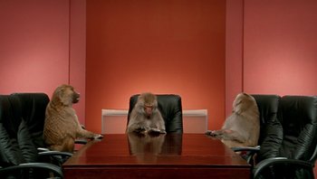 Movie still from “Fahrenheit 9/11” (2004), directed by Michael Moore – A group of monkeys sitting around a table; Wide shot, Low angle
