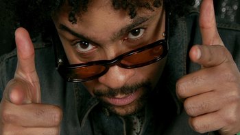 Movie still from “Fahrenheit 9/11” (2004), directed by Michael Moore – A person wearing glasses and a jean jacket; Extreme Close Up shot, Overhead angle