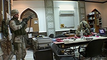 Movie still from “Fahrenheit 9/11” (2004), directed by Michael Moore – Two men in military fatigues in an office setting; Wide shot, Low angle