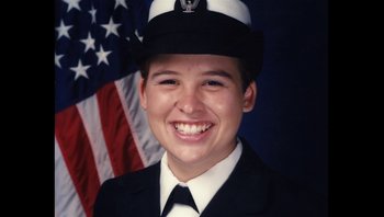 Movie still from “Fahrenheit 9/11” (2004), directed by Michael Moore – A woman in a uniform smiles for a picture; Close Up shot, Overhead angle
