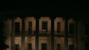 Movie still from “Fahrenheit 9/11” (2004), directed by Michael Moore – A white building with columns at night with lights; Extreme Wide shot, Low angle