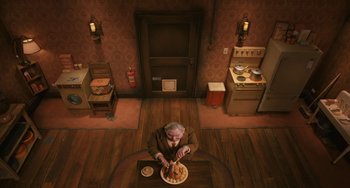 Movie still from “Fantastic Mr. Fox” (2009), directed by Wes Anderson – An older man sitting at a table with a cake; Wide shot, Overhead angle