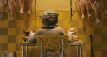 Movie still from “Fantastic Mr. Fox” (2009), directed by Wes Anderson – A woman sitting at a table with a plate of food; Medium shot, High angle