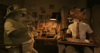 Movie still from “Fantastic Mr. Fox” (2009), directed by Wes Anderson – Two stuffed animals sitting next to each other in front of a desk; Medium shot, High angle