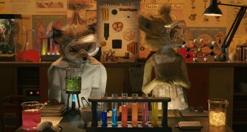 Movie still from “Fantastic Mr. Fox” (2009), directed by Wes Anderson – A couple of stuffed animals are sitting in a lab; Medium shot, High angle