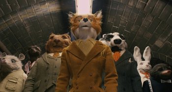 Movie still from “Fantastic Mr. Fox” (2009), directed by Wes Anderson – A group of dogs and a man in a suit and tie; Medium shot, Low angle