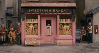 Movie still from “Fantastic Mr. Fox” (2009), directed by Wes Anderson – A bakery with a bunch of bread on the outside; Wide shot, High angle