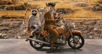 Movie still from “Fantastic Mr. Fox” (2009), directed by Wes Anderson – A group of people on a motor bike with masks on; Wide shot, High angle
