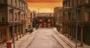 Movie still from “Fantastic Mr. Fox” (2009), directed by Wes Anderson – A painting of an empty street with a building on the corner; Extreme Wide shot, High angle