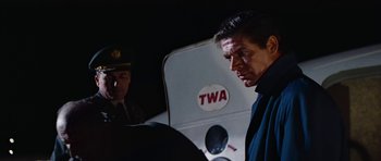 Movie still from “Fantastic Voyage” (1966), directed by Richard Fleischer – A man standing next to another man in front of an airplane; Close Up shot, Low angle