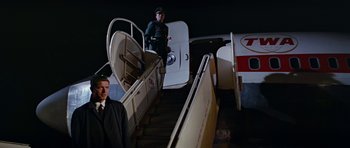 Movie still from “Fantastic Voyage” (1966), directed by Richard Fleischer – A man standing on the stairs of an airplane at night; Wide shot, Low angle