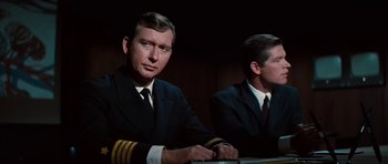 Movie still from “Fantastic Voyage” (1966), directed by Richard Fleischer – Two men in suits and ties sitting at a table; Close Up shot, Over the shoulder angle