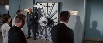 Movie still from “Fantastic Voyage” (1966), directed by Richard Fleischer – Two men standing in front of an open bank vault; Wide shot, Low angle
